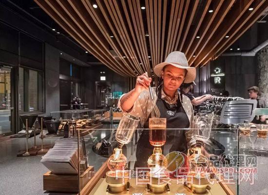 在一家设有Reserve咖啡吧的星巴克，一位员工使用虹吸式咖啡壶酿制咖啡。